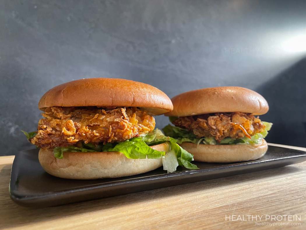 Fried chicken burger with crispy oven-baked chicken, brioche bun, spicy pickles, romaine lettuce, and light mayonnaise