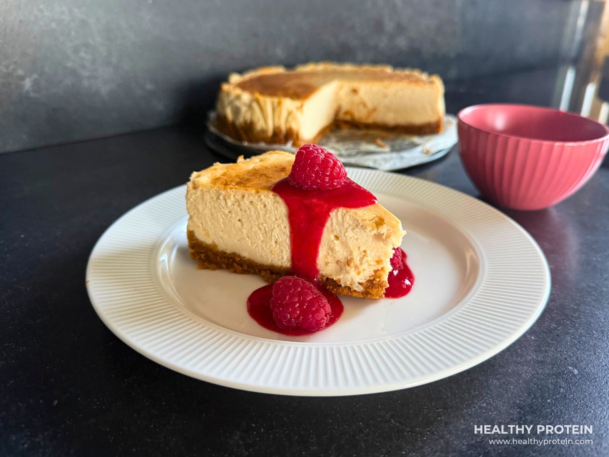 manhattani toorjuustukook cheesecake retsepti pilt vaarikate ja vaarikamoosiga asetatud valgele taldrikule