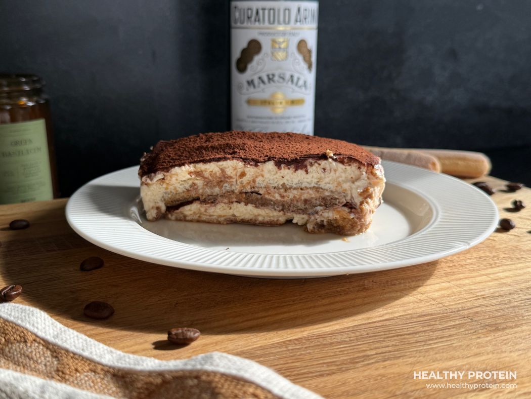 Tiramisu koogitükk, mille läbilõikes on näha õhulise mascarponekreemi ja kohvis immutatud küpsiste kihid